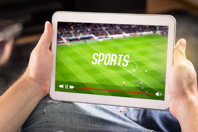 Man holding ipad watching football via fibre broadband